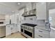 Bright kitchen with stainless steel appliances, white cabinets, and stone backsplash at 10683 Glenleigh Dr, Johns Creek, GA 30097