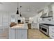 Bright kitchen with stainless steel appliances, island with seating, and view to living room with fireplace at 10683 Glenleigh Dr, Johns Creek, GA 30097