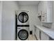 Laundry room featuring stackable washer and dryer and white cabinets at 10683 Glenleigh Dr, Johns Creek, GA 30097