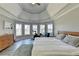 This main bedroom boasts a tray ceiling, exercise bike, and large windows offering ample natural light at 10683 Glenleigh Dr, Johns Creek, GA 30097