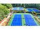 Aerial view of well-maintained tennis courts with vibrant blue and green surfaces for recreational play at 10683 Glenleigh Dr, Johns Creek, GA 30097