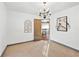 Bright dining room features a chandelier, artwork, and an open doorway leading to the upper level at 160 Deer Cliff Cv, Lawrenceville, GA 30043