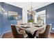 Blue dining room with modern chandelier, wainscoting, and a large square table at 160 Deer Cliff Cv, Lawrenceville, GA 30043