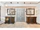 Elegant main bathroom featuring dual vanities with decorative mirrors, sinks, and storage cabinets at 160 Deer Cliff Cv, Lawrenceville, GA 30043