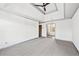 Large main bedroom with neutral carpet, a ceiling fan, tray ceiling, and an ensuite bathroom at 160 Deer Cliff Cv, Lawrenceville, GA 30043