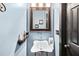 Stylish powder room with a unique vessel sink, decorative mirror, and a soothing blue color scheme at 160 Deer Cliff Cv, Lawrenceville, GA 30043