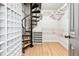 Well-organized walk-in closet with custom shelving, hanging rods, and a unique spiral staircase at 160 Deer Cliff Cv, Lawrenceville, GA 30043