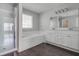 Bathroom featuring glass shower and bathtub combo with dual sink vanity and dark wood-look floors at 2845 White Blossom Ln, Suwanee, GA 30024