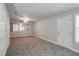 Large carpeted bonus room featuring a ceiling fan and natural light at 2845 White Blossom Ln, Suwanee, GA 30024