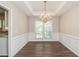 Elegant dining room featuring hardwood floors, chandelier, and wainscoting at 2845 White Blossom Ln, Suwanee, GA 30024