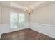 Formal dining room boasting hardwood floors, a chandelier, and wainscoting details at 2845 White Blossom Ln, Suwanee, GA 30024