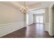 Formal dining space with hardwood floors, wainscoting, and an ornate chandelier at 2845 White Blossom Ln, Suwanee, GA 30024