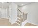Hallway view of staircase with white walls and hardwood floors at 5711 Tillman Way, Powder Springs, GA 30127