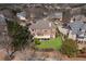 Aerial view of a brick house with a spacious backyard and a deck, nestled among mature trees at 1021 Windermere Xing, Cumming, GA 30041