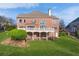 Expansive backyard featuring a lush lawn, a white deck, and a brick exterior with large windows at 1021 Windermere Xing, Cumming, GA 30041