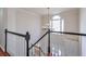 Elegant stairway with black and white railings, hardwood floors, and a charming chandelier at 305 Hembree Grove Trce, Roswell, GA 30076