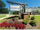 Landscaped entrance to Evanshire community with colorful flowerbeds, green bushes, and a prominent sign at 3187 Moor View Rd # 37, Duluth, GA 30096