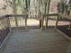 Wooden back porch with black metal railing overlooks a wooded backyard at 434 Ridgetop Nw Dr, Acworth, GA 30102