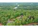 Aerial view of the home surrounded by lush trees and landscaping at 500 River Bluff Pkwy, Roswell, GA 30075