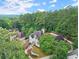 An expansive aerial view showing the home nestled in a lush, green, wooded area at 500 River Bluff Pkwy, Roswell, GA 30075