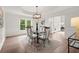 Elegant dining room with stylish chandelier, large windows, and a view of the home's entryway at 500 River Bluff Pkwy, Roswell, GA 30075