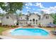 Stunning backyard pool with patio seating surrounded by manicured landscaping and a beautiful traditional home at 500 River Bluff Pkwy, Roswell, GA 30075