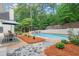 Backyard pool surrounded by patio, mulch beds, mature landscaping, and an outdoor dining area at 500 River Bluff Pkwy, Roswell, GA 30075