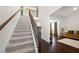 Inviting staircase with carpeted steps, hardwood flooring, and decorative wrought iron railing at 2880 Ridge Manor Dr, Dacula, GA 30019