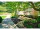 Beautifully landscaped front yard featuring lush greenery, mature trees, and a brick house at 2938 Summitop Ne Rd, Marietta, GA 30066
