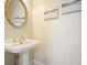 Charming powder room featuring a pedestal sink, decorative mirror, and elegant artwork at 2938 Summitop Ne Rd, Marietta, GA 30066