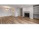 Bright living room featuring updated flooring, a cozy fireplace, and adjacent dining area with decorative lighting at 707 Woodcliff Dr, Atlanta, GA 30350