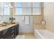 Bright bathroom featuring granite countertops, modern lighting, and a tiled shower over tub at 142 Perimeter Walk, Atlanta, GA 30338