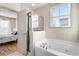 Bright bathroom features a soaking tub, separate shower, and an open doorway to the bedroom at 142 Perimeter Walk, Atlanta, GA 30338