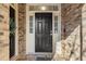 Inviting front door with decorative windows, a brick surround, and updated hardware at 142 Perimeter Walk, Atlanta, GA 30338