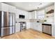 Modern kitchen featuring white cabinets, stainless steel appliances, and hardwood floors at 142 Perimeter Walk, Atlanta, GA 30338