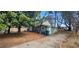 An exterior shot of a small home with mature trees and a long driveway on a sunny day at 2224 Elizabeth Se Ave, Smyrna, GA 30080