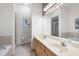 Bright bathroom featuring double vanity, soaking tub, and exposed brick wall at 1605 Ridenour Nw Pkwy, Kennesaw, GA 30152