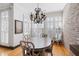 Elegant dining room featuring a vintage chandelier, exposed brick wall and plantation shutters at 1605 Ridenour Nw Pkwy, Kennesaw, GA 30152