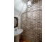 Unique powder room with a pedestal sink, exposed brick wall and elegant wallpaper at 1605 Ridenour Nw Pkwy, Kennesaw, GA 30152