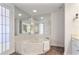 Bathroom featuring a marble-walled corner soaking tub and natural lighting at 3435 Kingsboro Ne Rd # 1701, Atlanta, GA 30326