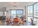Dining area with modern light fixture, hardwood flooring, and balcony access with city views at 3435 Kingsboro Ne Rd # 1701, Atlanta, GA 30326