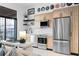 Modern kitchen with stainless steel appliances, wood cabinets, and views to the outdoor balcony at 567 Ponce De Leon Ne Ave # 317, Atlanta, GA 30308