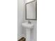 Chic half-bathroom featuring a pedestal sink and a decorative mirror at 901 Echo Park Dr, Suwanee, GA 30024