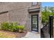 Front entrance of brick townhome featuring glass door and modern design elements at 901 Echo Park Dr, Suwanee, GA 30024