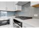 Modern kitchen featuring stainless steel appliances, white cabinetry, stylish backsplash and stone countertop at 901 Echo Park Dr, Suwanee, GA 30024