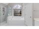 Bright bathroom featuring a shower, a bathtub, and an arched window at 1224 Indian Hills Pkwy, Marietta, GA 30062
