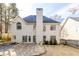 Back exterior of a home with a large stone patio and mature trees, perfect for outdoor entertaining or relaxation at 1224 Indian Hills Pkwy, Marietta, GA 30062