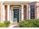 Elegant home entrance featuring a green front door, brick facade and lush landscaping at 1224 Indian Hills Pkwy, Marietta, GA 30062