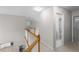 Open hallway featuring a wooden railing, neutral walls, and views into the kitchen and bathroom at 1224 Indian Hills Pkwy, Marietta, GA 30062
