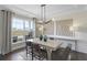 Elegant dining room with a modern chandelier, shiplap accent wall, and large windows showcasing the view at 4246 Azalea Ridge Way, Hoschton, GA 30548